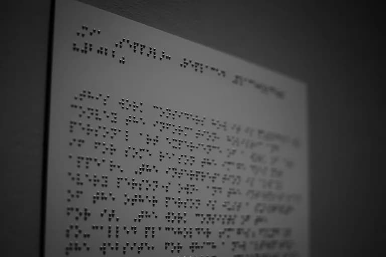 Kabartma Braille yazısıyla basılmış bir sayfa, yakın plan